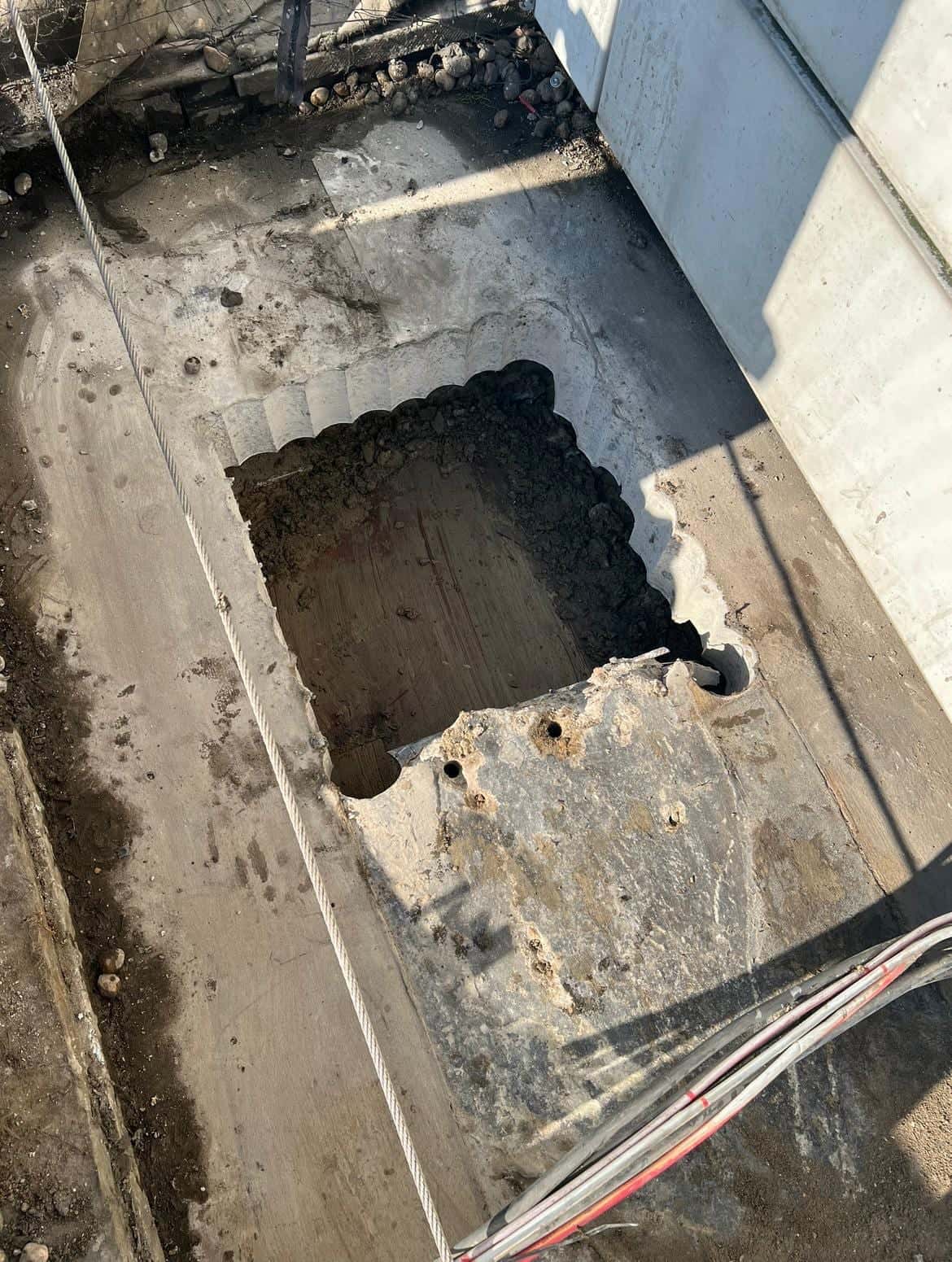 Partly cleared rectangular opening with scalloped stitch-drilled edges in a concrete roof slab