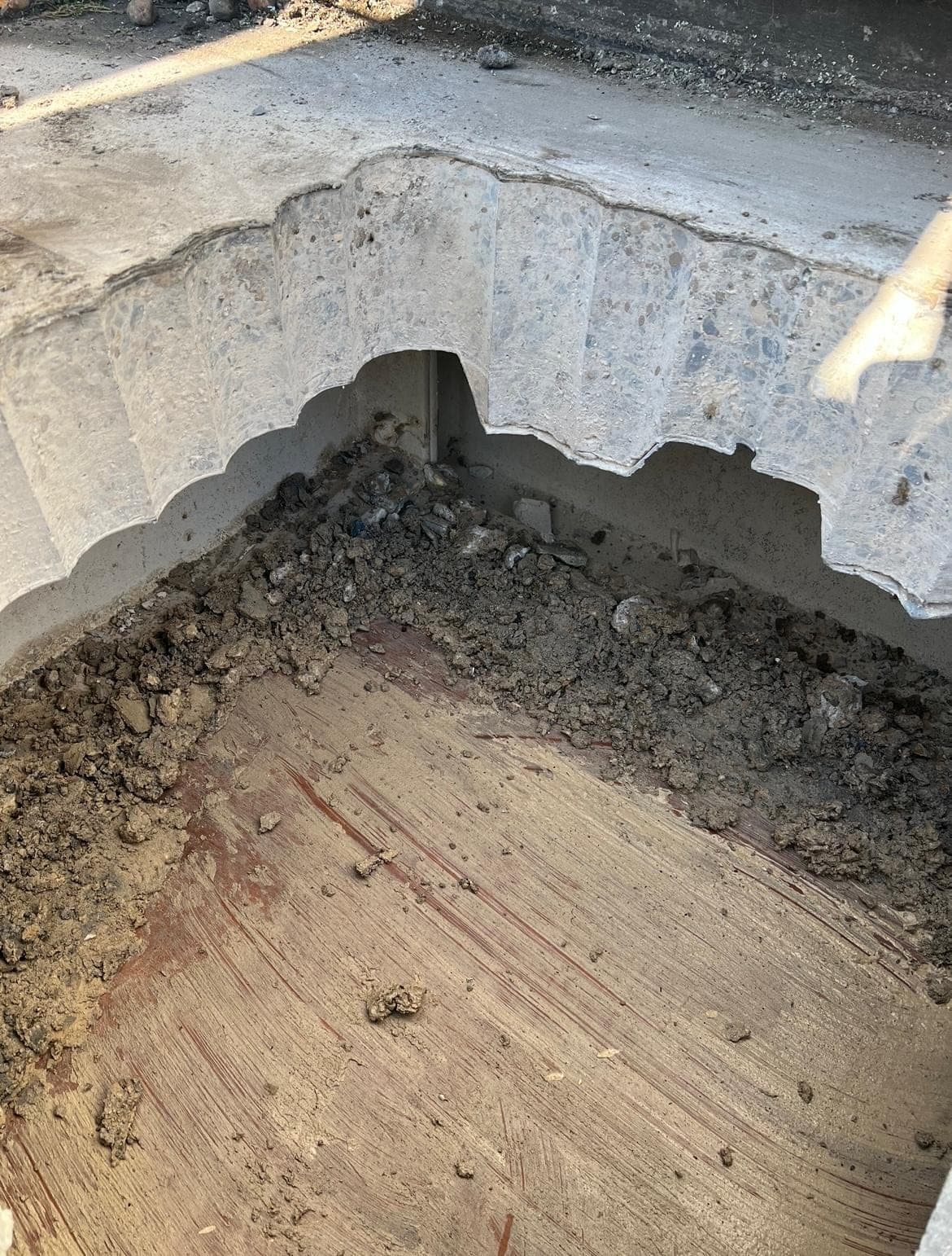 Edge of a thick concrete slab showing the scalloped profile left by overlapping core holes